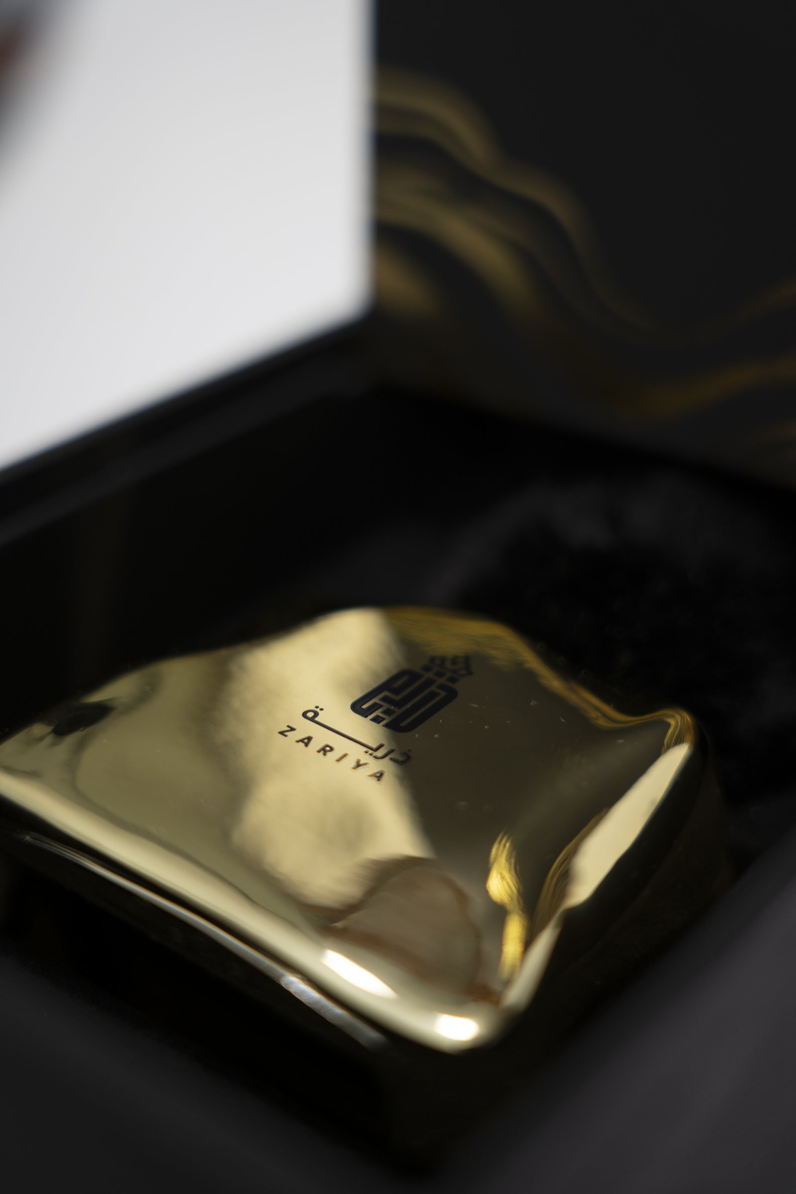 A Zariya gold bottle nestled in its black and gold gift box